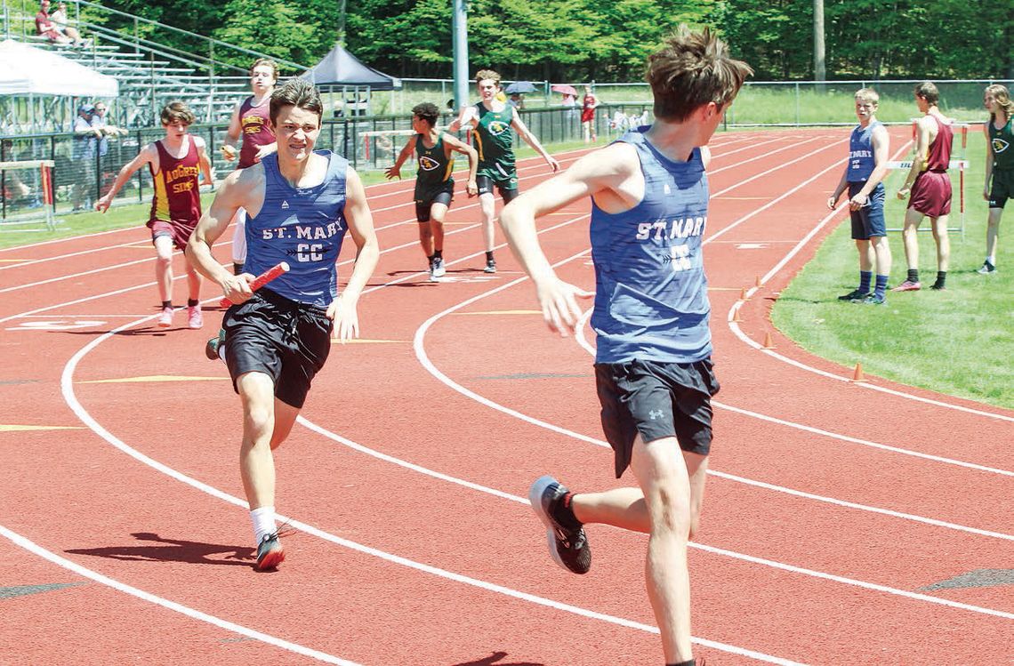 Lake Leelanau St. Mary runners Derek Graham hands off to Garrick Collins during a MHSAA Div. 4 regional on Saturday. The 4x800-relay team of Oliver Mitchell, Garret Grant, Graham, and Collins qualified for the state track meet for the first time in school history. Enterprise photos by Bria...