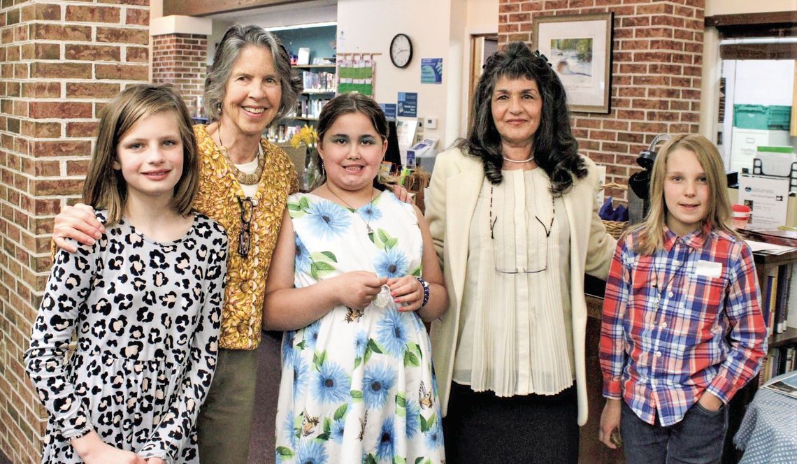 Northport Public School students (from left to right) Charlotte Murphy, Arya Cavendish, and Pierson Humphrey are pictured with Leelanau Township Library Poetry Month Chair Alison Arthur and library assistant Marie Gaspari during open mic night last year. Courtesy photo