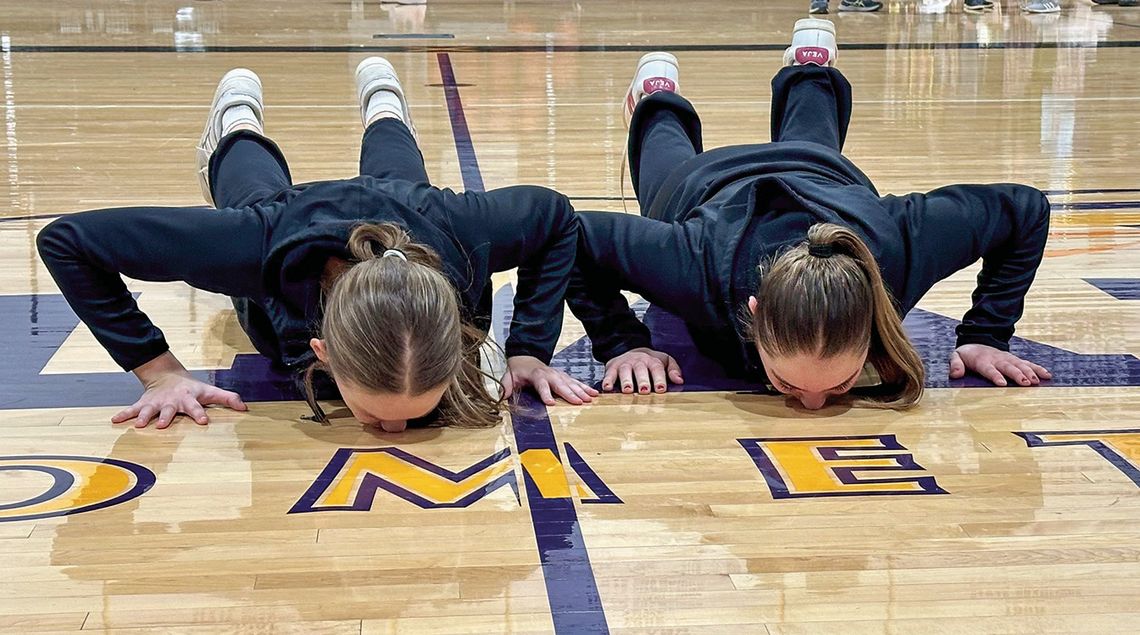 Leland girls basketball seniors Ella Seguin (left) and Mallory Lowe (right) kiss the Comets basketball court on senior night. Courtesy photo