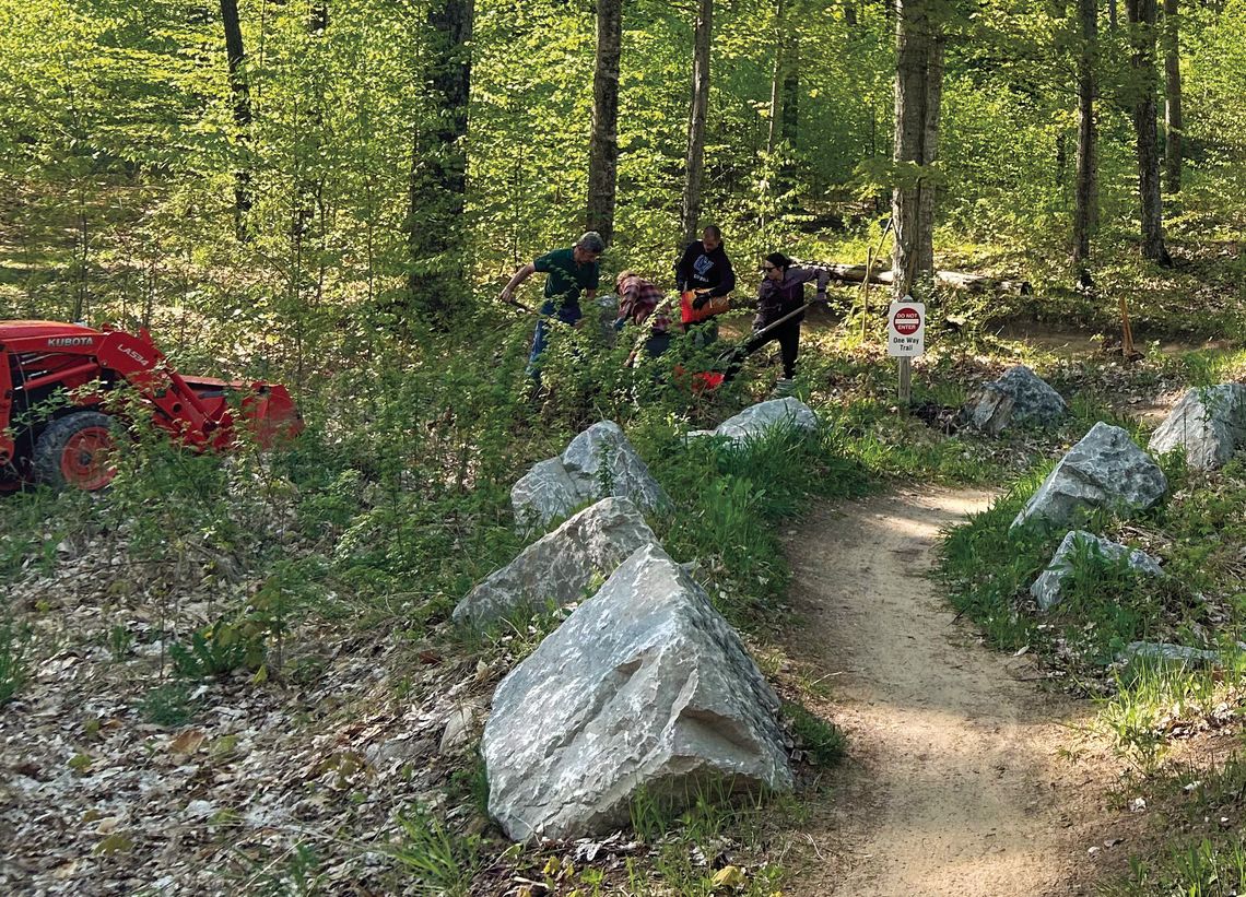 Members and volunteers of the Leelanau Conservancy are seen hard at work Members and volunteers of the Leelanau Conservancy are seen hard at work, maintaining the mountain bike trails at Palmer Woods Forest Reserve Tuesday night. Enterprise photo by Everett Howell
