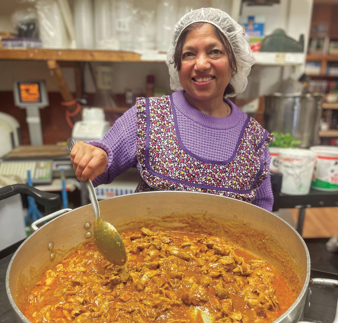 Regani Punheni, otherwise known as 'Rosie', cooking chicken curry at NJ's Grocery in Lake Leelanau. Enterprise photo by Brian Freiberger