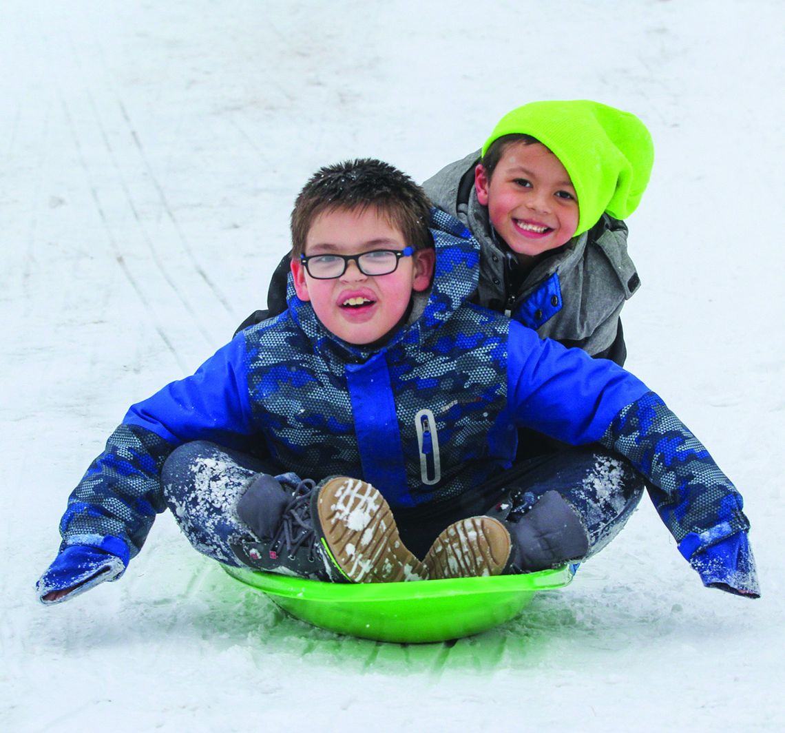 Nobody enjoyed the snow more than several Suttons Bay second graders that had some fun during recess last week Nobody enjoyed the snow more than several Suttons Bay second graders that had some fun during recess last week. Declan Chippewa-Gillard (left), Gabriel Harper (right) share a thrilling ride on the playground. Enterprise photo by Brian Freiberger