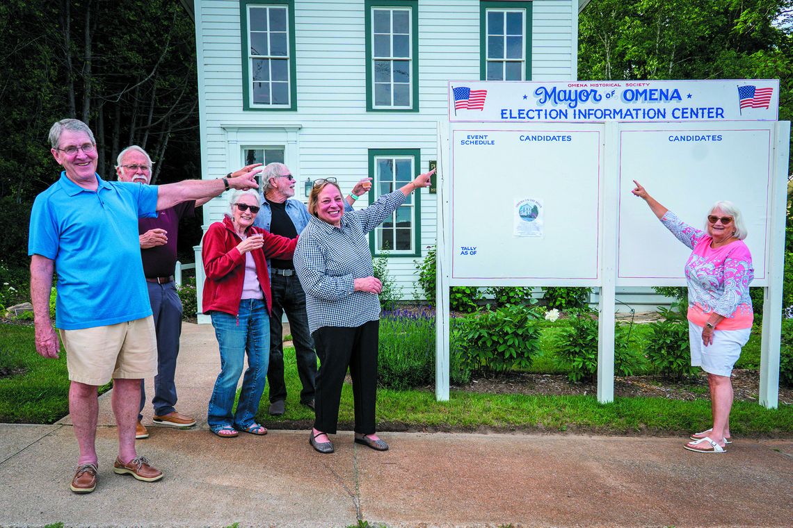 The Omena Historical Society launched its triennial Omena Mayor elections this past Monday. Pictured at the Election Center in front of the museum are, from left, Jeff Heitzman, Steve Stanton, Barb Grosmark, Harold McKee, Marsha Buehler, and Lauris Woolford. Photo by Mark Smith