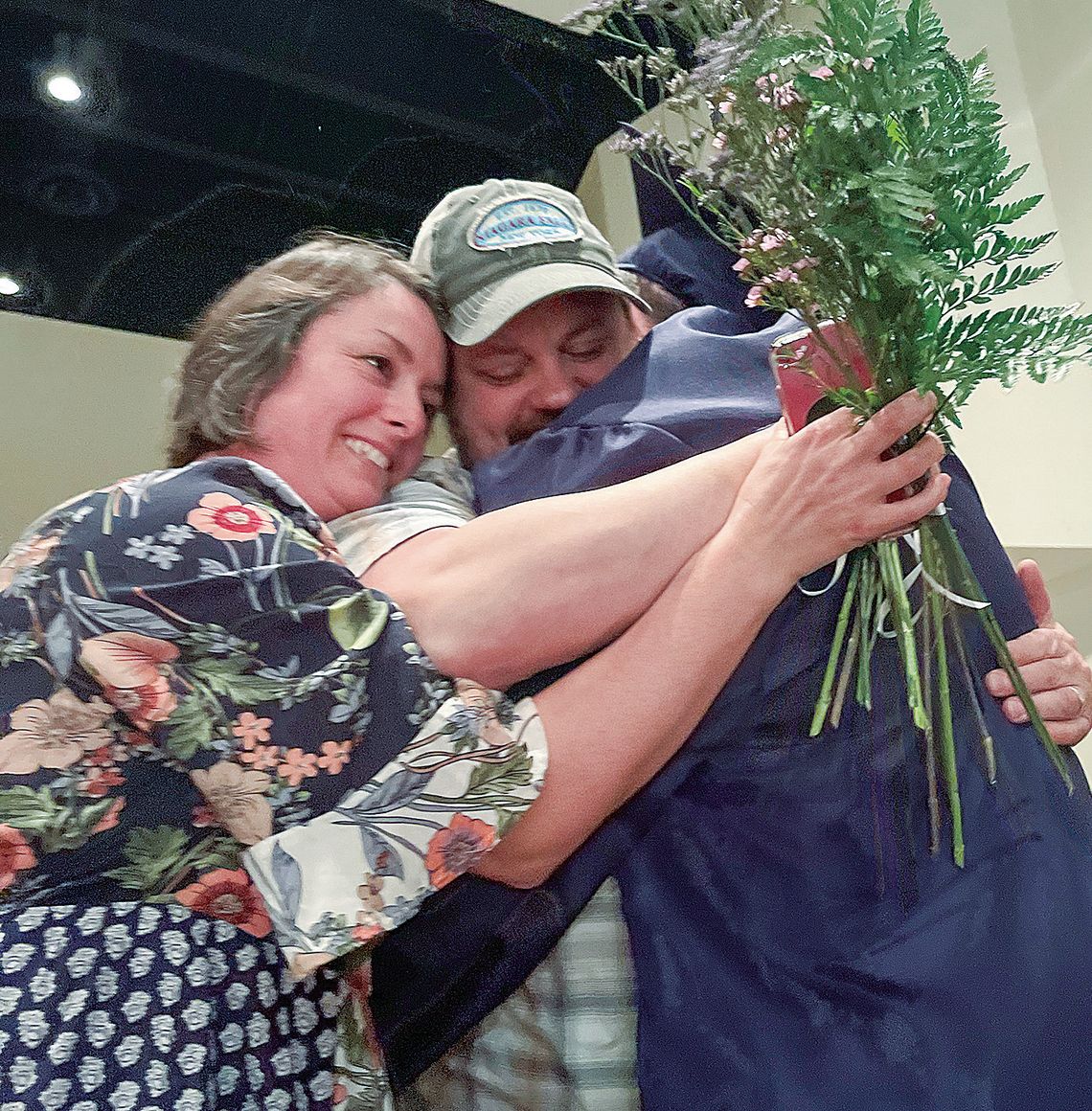 Northport Public School senior Dashel Courson embraces family members during the presentation of the parent flower ceremony at Friday’s graduation.