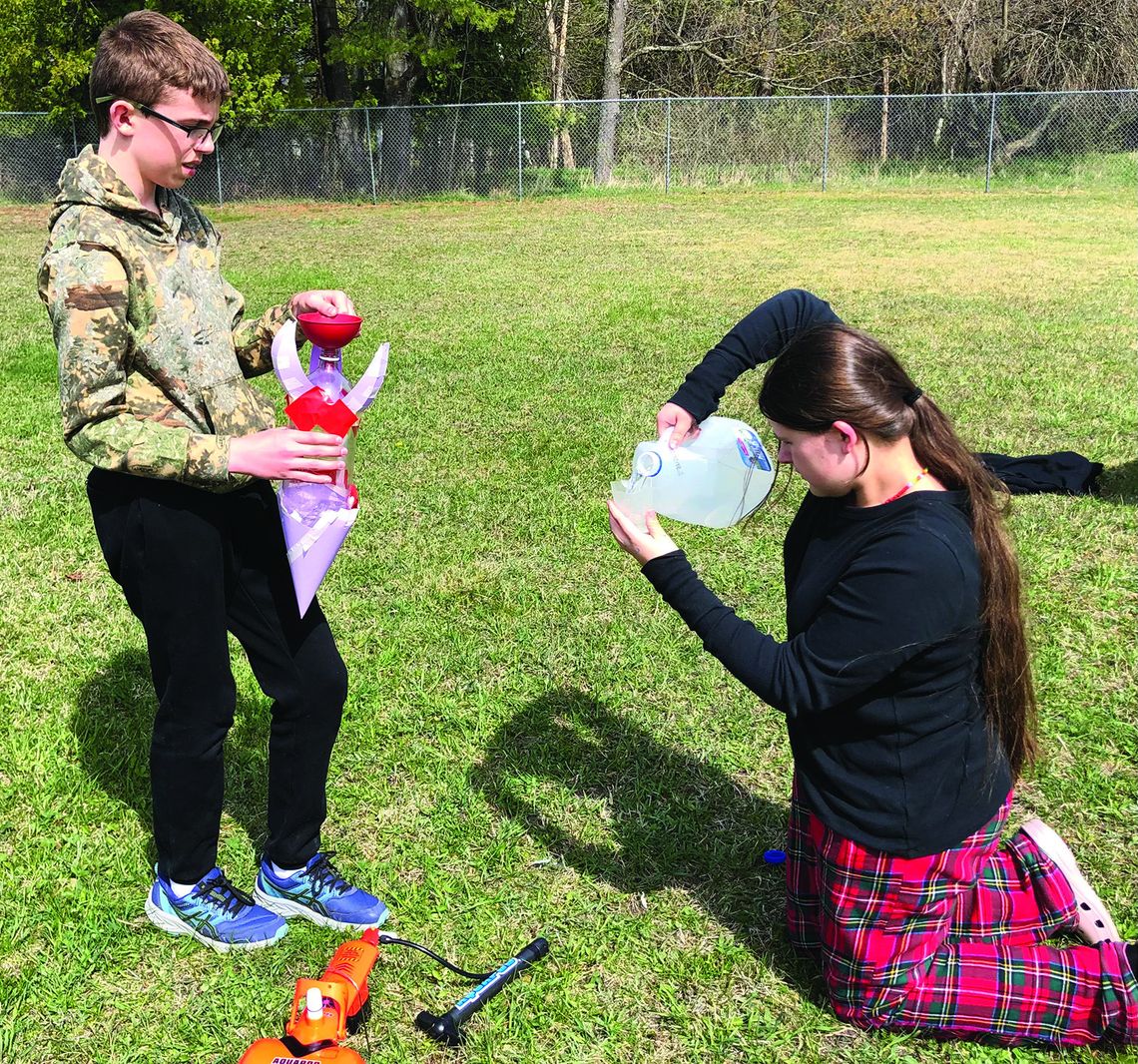 Northport Public School 8th grader Jack Scripps (left) and 7th grader Lilly Gmoser-Duhamel (right) carefully measure the water to add to their rocket on rocket launch day as part of the NASA Artemis Challenge. Photo courtesy of Karen Trolenberg