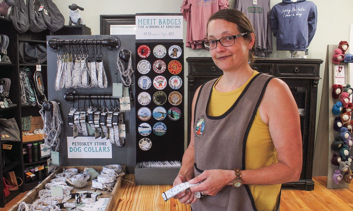 Meg Paxton shows off her original Petoskey Stone Dog Collars at The Blue Maple Corner in Maple City. Enterprise photo by Brian Freiberger