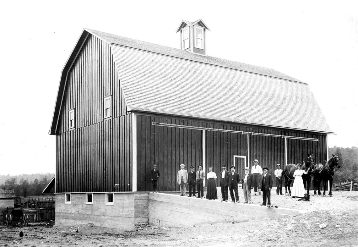 A photograph of the Poor Farm Barn in 1911 shows the original cupola atop the barn’s roof. The builder of the barn, John Schettek, is within the foreground. Photo courtesy of Leelanau County Historic Preservation Society