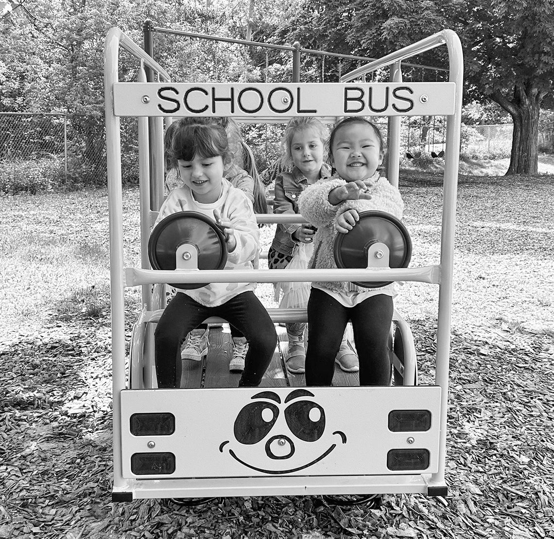St. Mary preschoolers Madelyn Loomis, Olivia Hebert and Valentine Moua enjoy driving the new St. Mary School playground bus generously funded by the Oleson Foundation. Courtesy photo