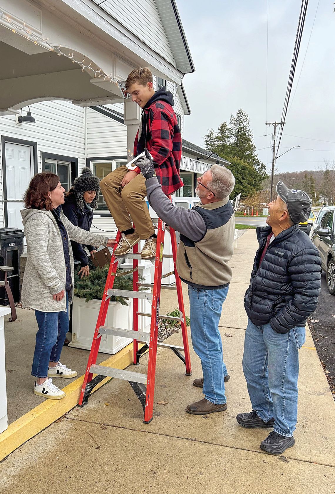 Decking the halls in the village of Omena are, from left, Kerri Magrini, Susan Krusel, William Krusel (on ladder), Bill Krusel and Bob Nakamura. Courtesy photo