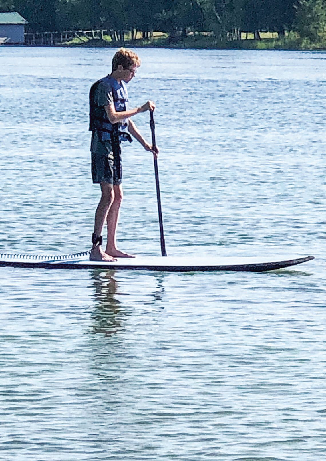 Warmer temperatures hasten water activities. This lone paddleboarder braved the water on Fisher Lake near Glen Arbor. Enterprise photo by Amy Hubbell