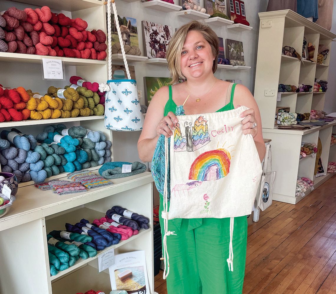 Liz Neddo of Wool and honey of Cedar holds an art piece that her daughter Cecily made. Enterprise photo by Brian Freiberger